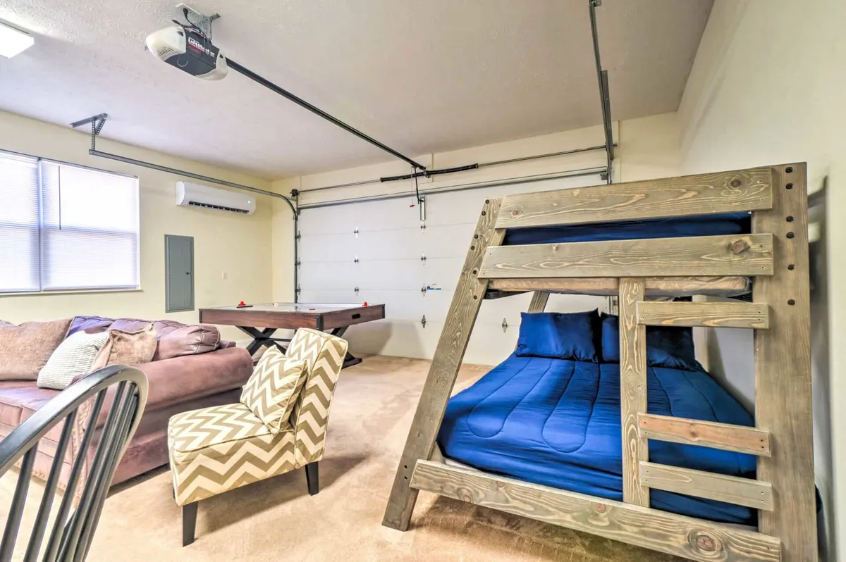 A playful, multi-purpose game room features a cozy sofa, bunk bed, game table, and a unique zigzag chair. The space is primed for friendly competition, group games, or movie marathons, echoing the lively, fun-filled group experiences described in the section.