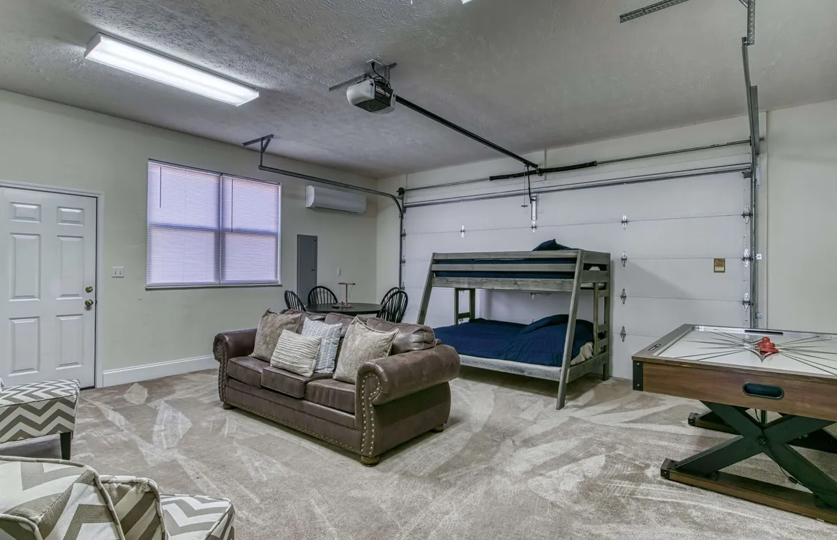 A fun, versatile space featuring a bunk bed, plush sofa, and an air hockey table. This room blends rest with recreation, offering both a spot for games and a cozy nook for unwinding after activities.